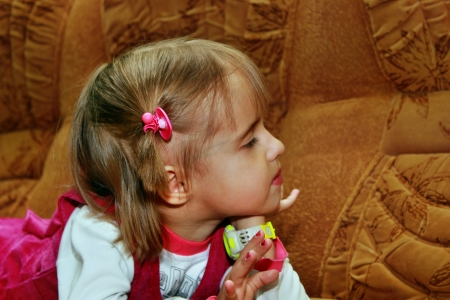 Little girl resting on the sofa, his head turned to the sideの写真素材
