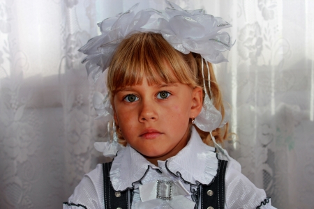 Portrait of the blonde girl behind a school deskの写真素材