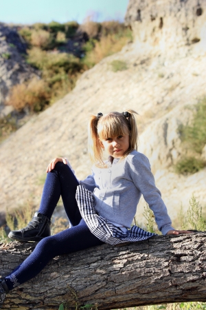 Girl resting in nature, sitting on a tree stumpの写真素材