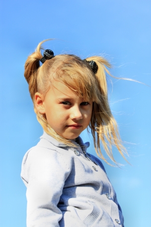 Portrait of blonde girl on a background of blue skyの写真素材