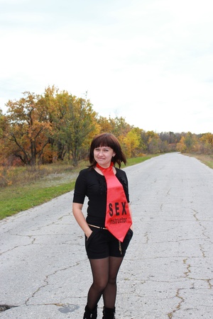 Happy brunette standing on the road near the woodsの写真素材