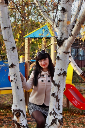 Beautiful girl in the children's park near the birchesの写真素材