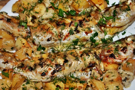 Fried potatoes with fish on a plateの写真素材