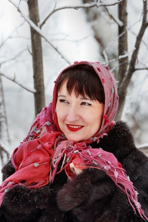 Portrait of beautiful smiling girl wearing a scarf in the winter woodsの写真素材