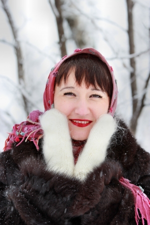 Pretty girl in pink scarf and white mittens in the winter woodsの写真素材