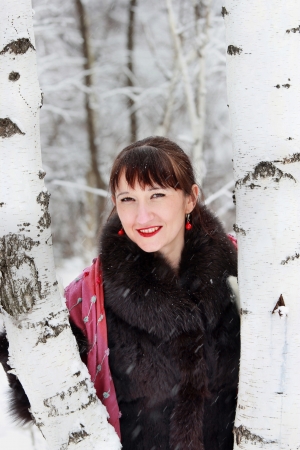 Portrait of a beautiful woman in a winter forest near two birchesの写真素材