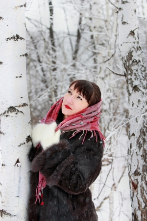 Thoughtful girl in a winter forest near birchesの写真素材