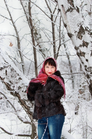 Girl in a snowy forest near the birchesの写真素材