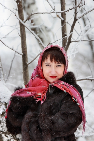 Pretty woman in pink scarf in the winter woodsの写真素材