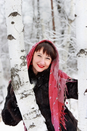 A smiling girl in a winter forest near birchesの写真素材