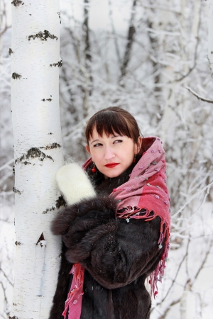 Girl in winter forest near birch, looking awayの写真素材