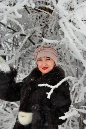 Beautiful girl among the snowy winter forest bushesの写真素材