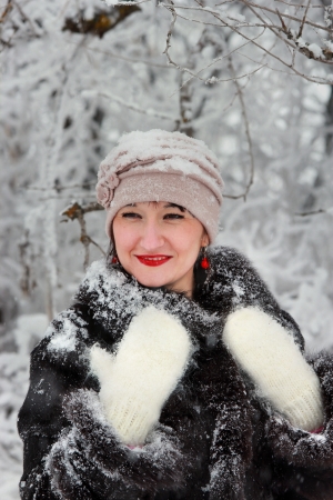 Happy girl in white mittens in the winter woodsの写真素材