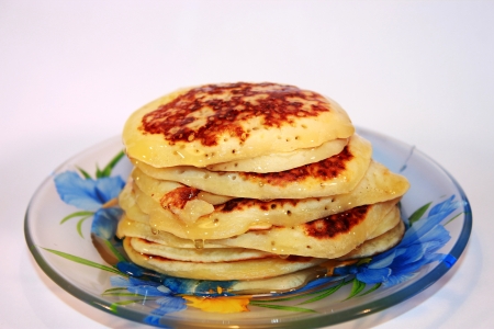 A stack of thin pancakes with honeyの写真素材