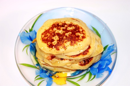 Small pancakes with honey on a plateの写真素材