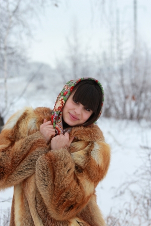 Smiling girl in fox fur coat in winter forestの写真素材