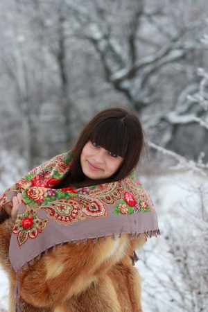 Beautiful girl in a fur coat and scarfの写真素材