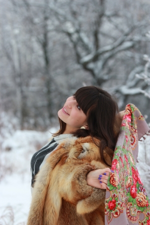 Happy girl enjoying a walk in the winter woodsの写真素材