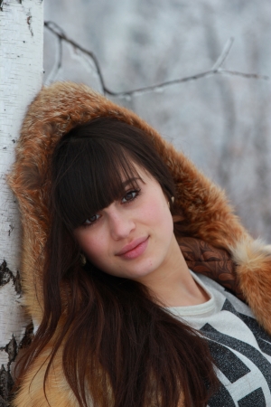 Portrait of a young girl in fox fur coat in winter forestの写真素材