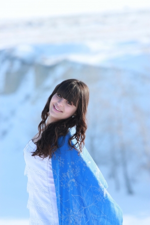 Happy brunette woman in white dress and cape on a beautiful natureの写真素材