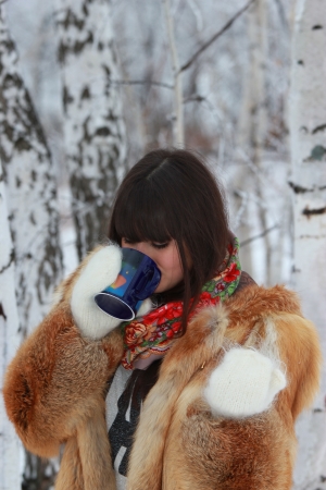A young girl with a cup of tea in the woodsの写真素材