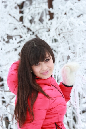 Portrait of a smiling girl near the snow-covered treeの写真素材