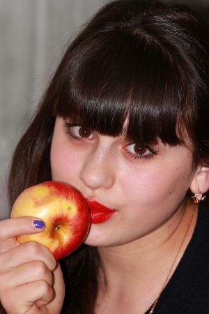 Portrait of a girl with a red apple in handの写真素材