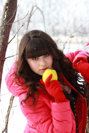 Girl in the woods, holding a yellow appleの写真素材