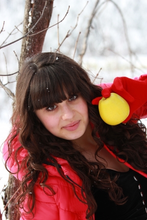 Girl in winter forest with an apple in his handの写真素材