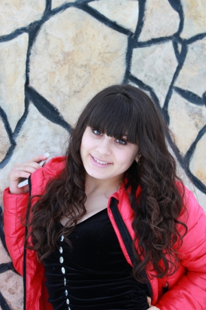 A smiling girl in a pink jacket black dress, Bose stone wallの写真素材