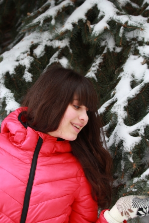 Happy young girl near the snow-covered firの写真素材
