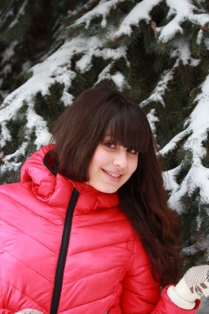 Beautiful girl in winter snow covered fir nearの写真素材