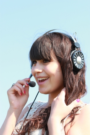 Happy brunette in headphones with microphoneの写真素材