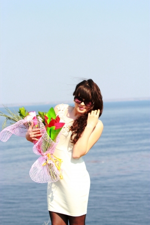 Young girl in sunglasses with a bouquet of rosesの写真素材