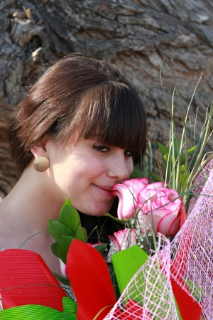 Young brunette enjoys the scent of rosesの写真素材