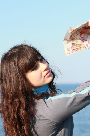 Young brunette with a five-thousand dollar bills in her handの写真素材