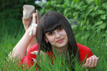 Portrait of a young girl lying on the grassの写真素材
