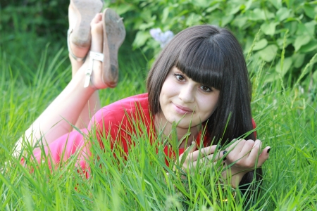 Happy brunette relaxing in nature, lying on the grassの写真素材