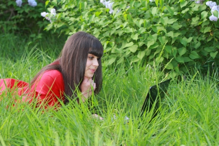 Young brunette with a laptop in the grassの写真素材