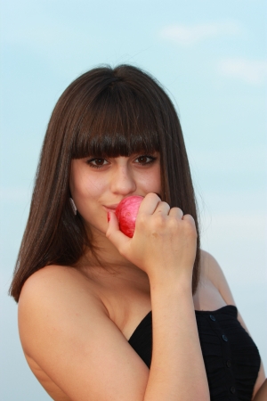 Young brunette with an apple in his handの写真素材