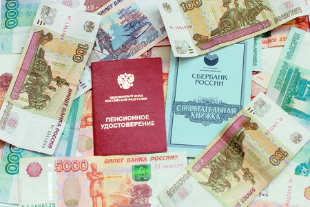 Pension card and savings book on the background of the Russian moneyの写真素材