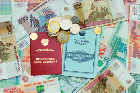 Pension card and savings book on the background of Russian moneyの写真素材