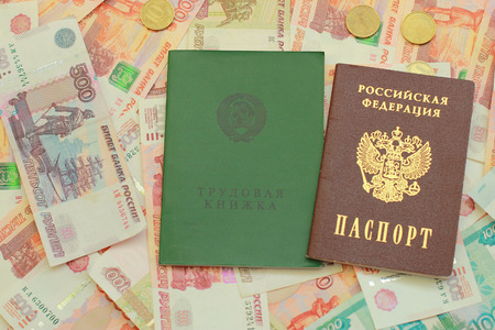 Russian passport and employment history are on the Russian money close upの写真素材