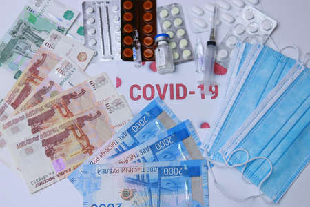 Russian money, medicine against the virus, protective masks and the inscription COVID-19.の写真素材