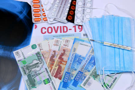 COVID-19. Coronavirus and the flu epidemic. Chest X-ray, various pills, a document on temporary disability, a thermometer against the background of Russian moneyの写真素材