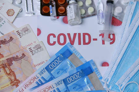 Antibiotics against coronavirus, pills, syringe, medical masks and Russian money, against the background of the inscription COVID-19.の写真素材
