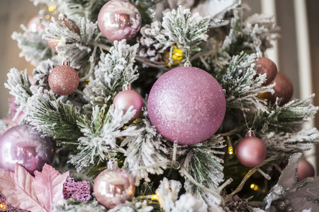 Pink Christmas tree decorations in the form of spheres close up on a green fir-tree. New year. Christmas.の写真素材