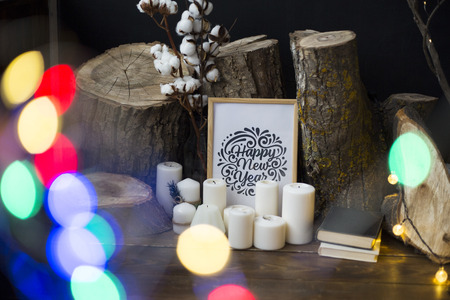 Composition from a frame with an inscription Happy New Year, candles, fellings of the trees against...