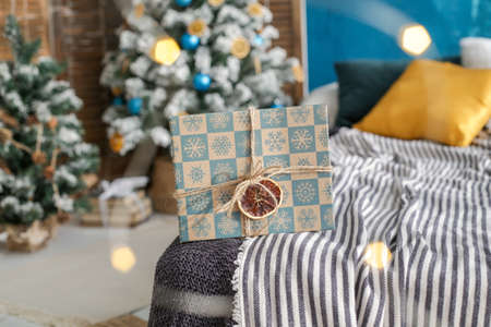 the box with a new year's gift is Packed by hand, decorated with a rope and a piece of dried orange...
