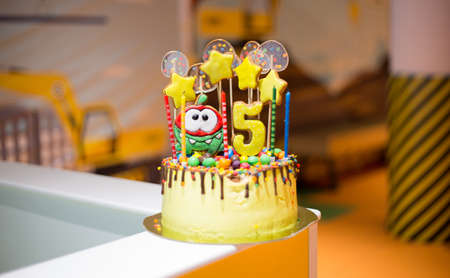 yellow beautiful delicious chocolate cake with gingerbread decorations. Edible stars and candy on...